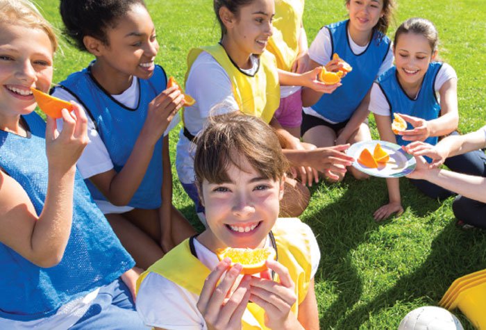 Junior girls having healthy snack break